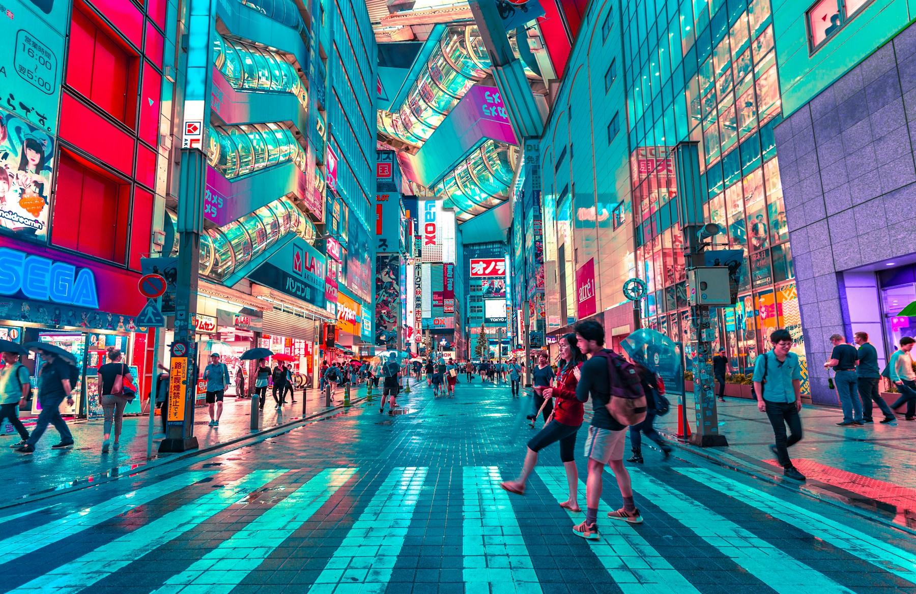Viajeros cruzando una avenida iluminada de Tokio